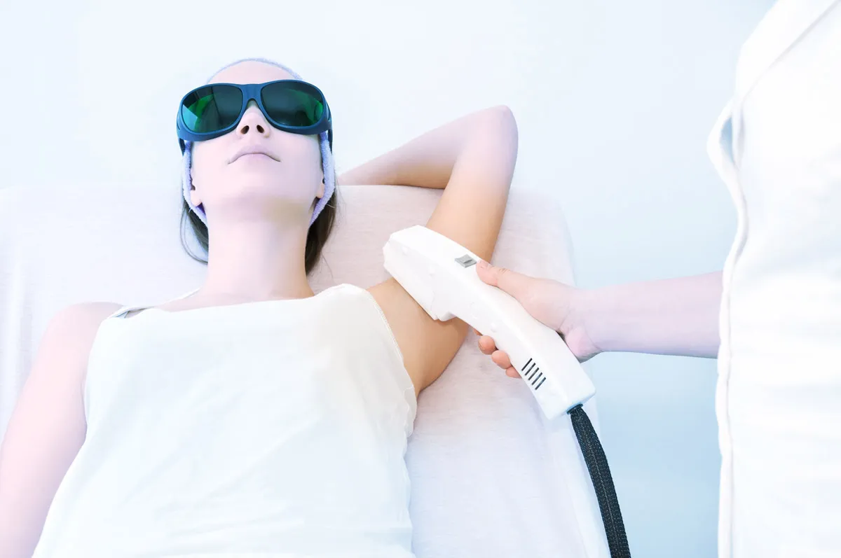 Bei einer Frau wir ein medizinisches Gerät auf den inneren linken Oberarm gehalten