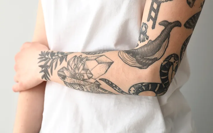 Linker Arm mit vielen Tattoos